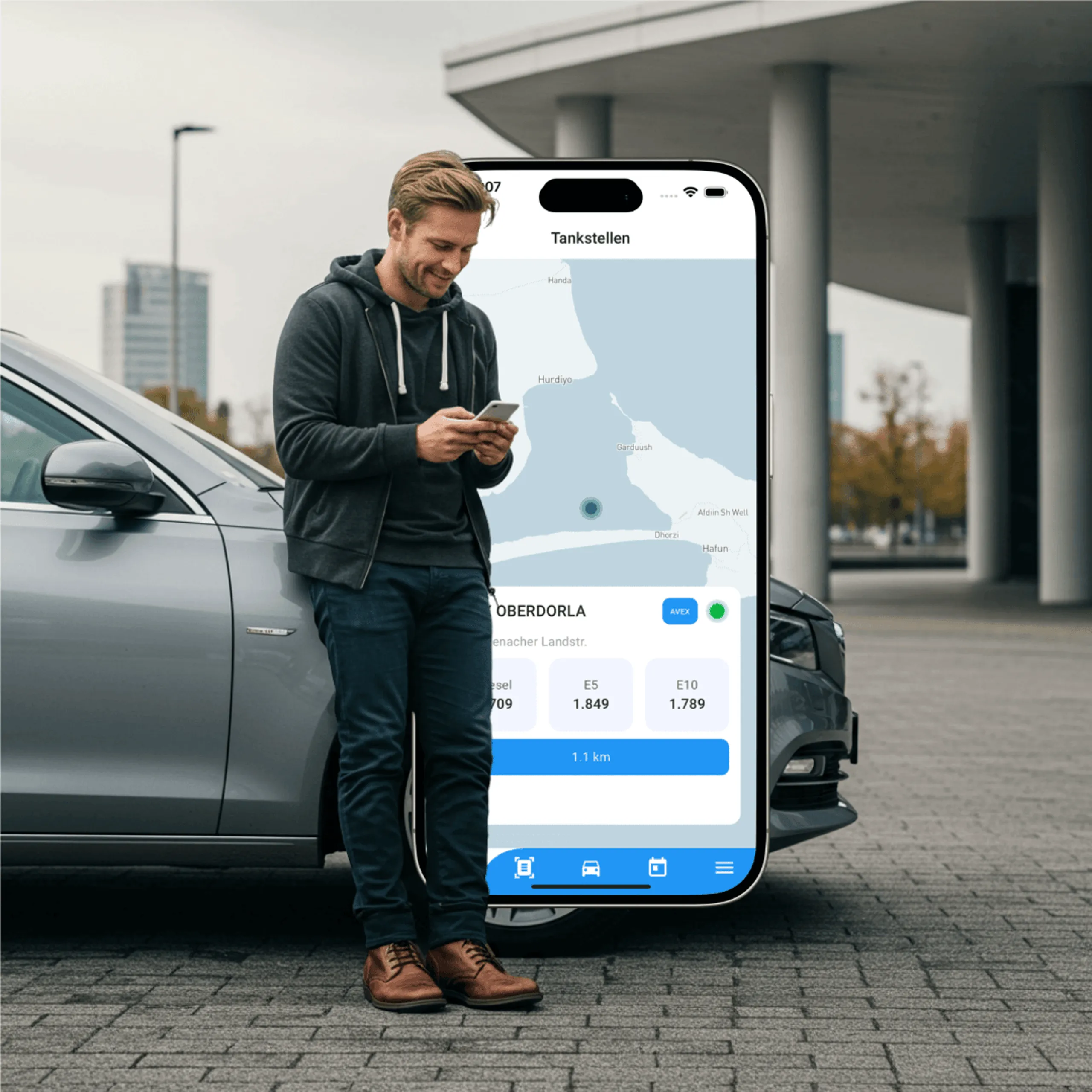 Autofahrer an einer Tankstelle prüft die Spritpreise in der Drivinger App auf seinem Smartphone.